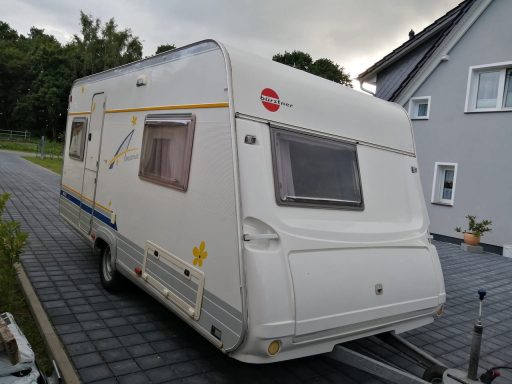 Wagen von vorn, weiß mit Streifen in grau, blau, gelb