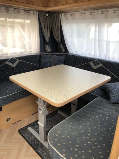 Rundsitzgruppe im forderen Fahrzeugbereich. Faltbarere Tisch um eine Liegefläche zu bilden. Polster blau gemustert.